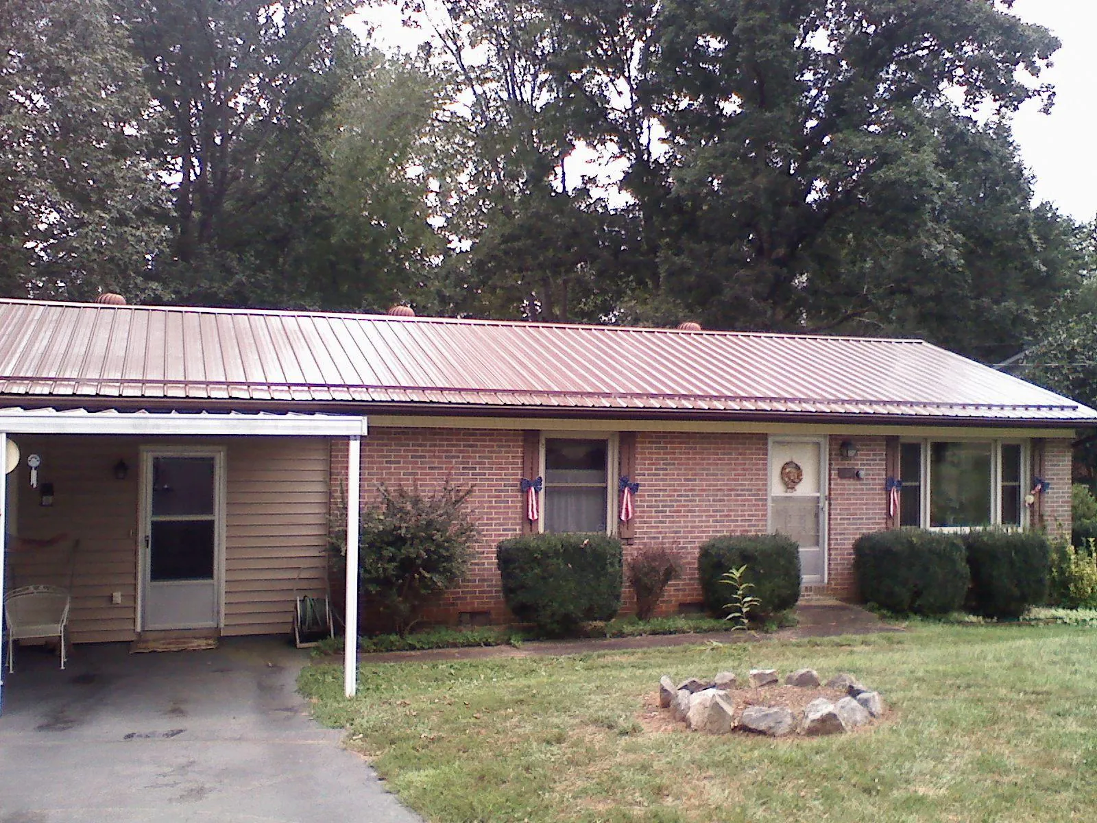 Bronze metal roof and carport on a brick ranch home — Roof Repair work by our crew in Taberg